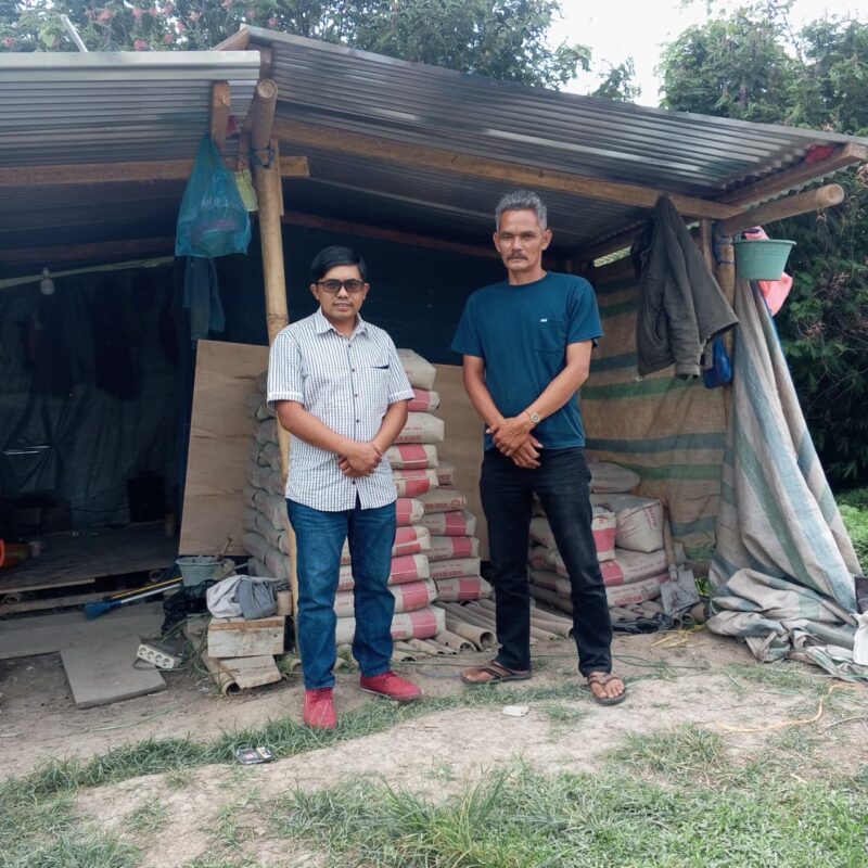 Jeksen memberikan sumbangan semen kepada Ngapul Tarigan dalam pembangunan gereja Katolik Desa Bandar Meriah